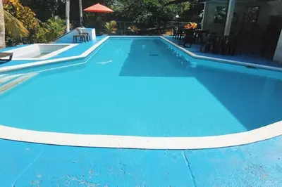 a blue swimming pool with a white border at Hermoso Duplex campestre in Honda