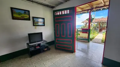 a red door in a room with a tv and a door at Finca Carrizales in Jardin