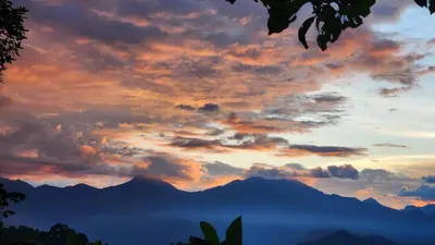 a sunset with mountains in the background at Finca Carrizales in Jardin