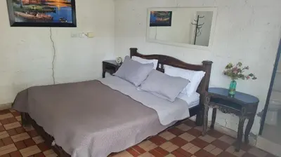 a bed with white sheets and pillows in a bedroom at Siboney hotel in Honda