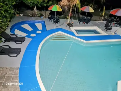 a blue swimming pool with chairs and umbrellas at Siboney hotel in Honda