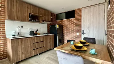 a kitchen with a wooden table with bowls on it at Ubicación Privilegiada Laureles Medellin con Vista y AC in Medellín