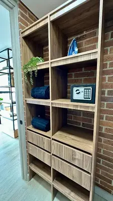 a wooden book shelf with a clock on it at Ubicación Privilegiada Laureles Medellin con Vista y AC in Medellín