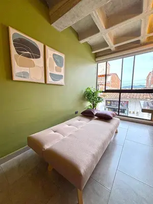 a large couch in a room with a green wall at c202 - Loft, hab1, baño 1, 1tv, sofacama, wifi in La Ceja
