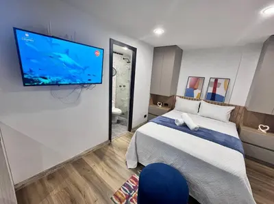 a bedroom with a bed and a flat screen tv on a wall at 1905 Apto con estilo & moderno poblado in Medellín