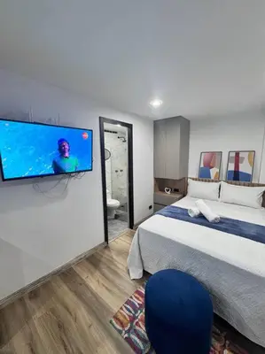 a bedroom with a bed and a tv on a wall at 1905 Apto con estilo & moderno poblado in Medellín