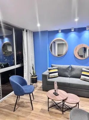 a living room with a couch and a blue wall at 1905 Apto con estilo & moderno poblado in Medellín