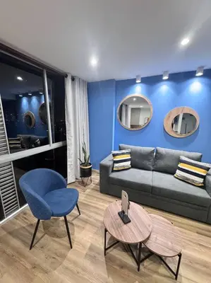 a living room with a couch and a blue wall at 1905 Apto con estilo & moderno poblado in Medellín