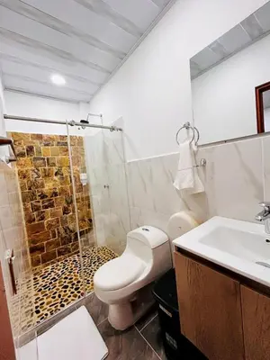 a bathroom with a toilet and a shower and a sink at Hotel Glorial in Doradal