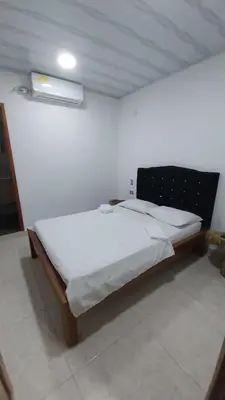 a bedroom with a bed in a white room at Hotel Glorial in Doradal