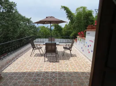 a patio with a table and chairs and an umbrella at Casa de Campo en Jardín Alojamiento Familiar in Jardin