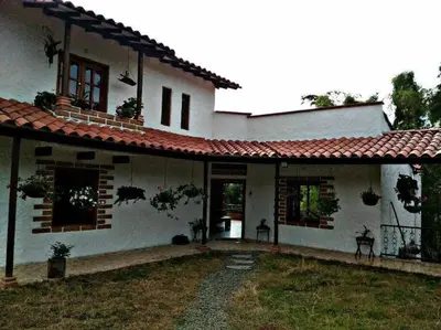 a white house with a red roof at Casa de Campo en Jardín Alojamiento Familiar in Jardin