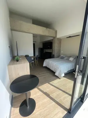 a bedroom with a bed and a table and a chair at Apartamento con vista y aire acondicionado cerca a El Tesoro in Medellín