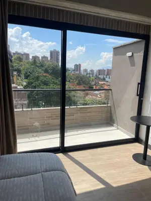a bedroom with a large window with a view of the city at Apartamento con vista y aire acondicionado cerca a El Tesoro in Medellín