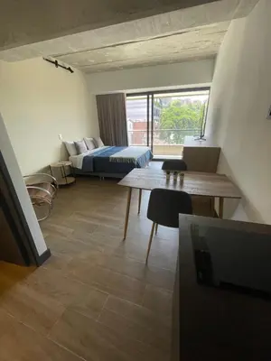 a hotel room with a bed and a table at Apartamento con vista y aire acondicionado cerca a El Tesoro in Medellín