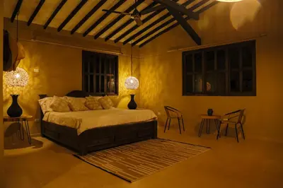 a bedroom with a bed and two tables and chairs at Finca Hotel Sawa in Maceo