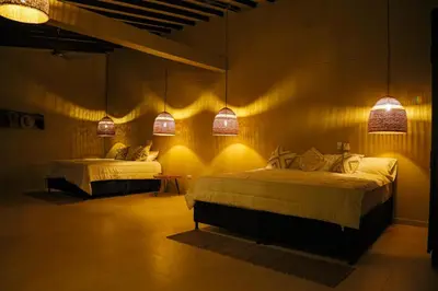two beds in a room with lights on the wall at Finca Hotel Sawa in Maceo