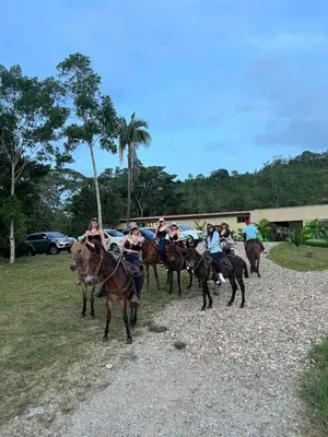 a group of people riding horses in a field at Finca Hotel Sawa in Maceo