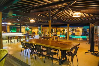 a large wooden table and chairs in a room at Finca Hotel Sawa in Maceo
