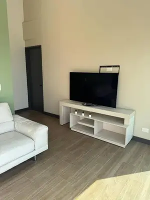 a living room with a television and a white couch at Apartamento 406 Poblado Cerca al CC El Tesoro in Medellín