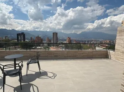 a patio with two chairs and a table on a roof at Apartamento 406 Poblado Cerca al CC El Tesoro in Medellín