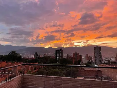 a sunset over a city with buildings and mountains at Apartamento 406 Poblado Cerca al CC El Tesoro in Medellín
