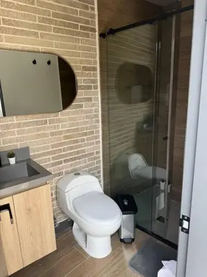 a bathroom with a toilet and a glass shower at Apartamento 406 Poblado Cerca al CC El Tesoro in Medellín