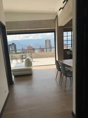 a living room with a couch and a table with a view at Apartamento 406 Poblado Cerca al CC El Tesoro in Medellín