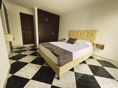 a bedroom with a large bed with a checkered floor at Vacacional, Casa ideal cerca a zona turística in Medellín