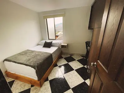 a bedroom with a bed and a checkered floor at Vacacional, Casa ideal cerca a zona turística in Medellín