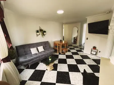a living room with a couch and a checkered floor at Vacacional, Casa ideal cerca a zona turística in Medellín