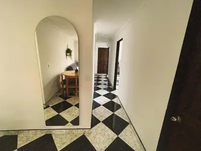 a hallway with a mirror and a black and white checkered floor at Vacacional, Casa ideal cerca a zona turística in Medellín