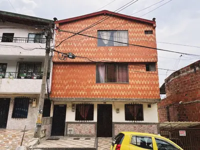 a yellow car parked in front of a building at Vacacional, Casa ideal cerca a zona turística in Medellín