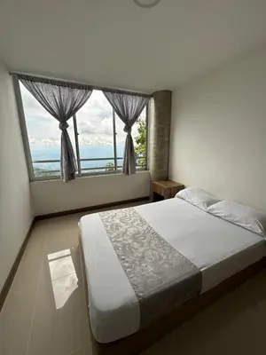 a bedroom with a bed and a large window at Sector Tranquilo y Central, Excelente Vista in Manizales