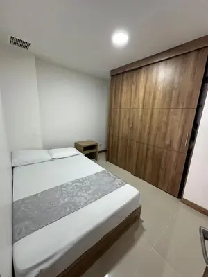 a bedroom with a bed and a wooden wall at Sector Tranquilo y Central, Excelente Vista in Manizales