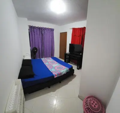 a bedroom with a bed and a chair and a television at Restaurante Saman in Santa Fe de Antioquia