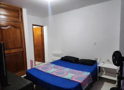 a bedroom with a blue bed and a sink at Restaurante Saman in Santa Fe de Antioquia