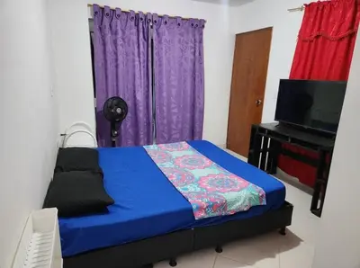 a bedroom with a bed and a tv and purple curtains at Restaurante Saman in Santa Fe de Antioquia