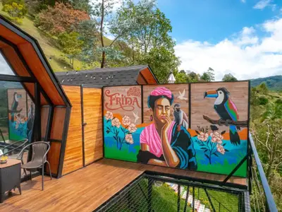 a mural on the side of a house with a deck at La Finca De Frida in Guatapé