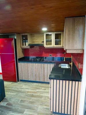 a kitchen with a black counter top and wooden cabinets at La Finca De Frida in Guatapé