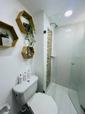 a white bathroom with a toilet and a shower at Apartamento Piscina sabaneta Medellín 20 minutos Poblado in Envigado