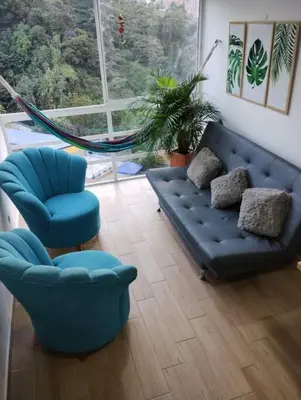 a living room with a blue couch and two chairs at Apartamento Piscina sabaneta Medellín 20 minutos Poblado in Envigado
