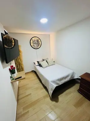 a bedroom with a bed and a flat screen tv at Apartamento Piscina sabaneta Medellín 20 minutos Poblado in Envigado
