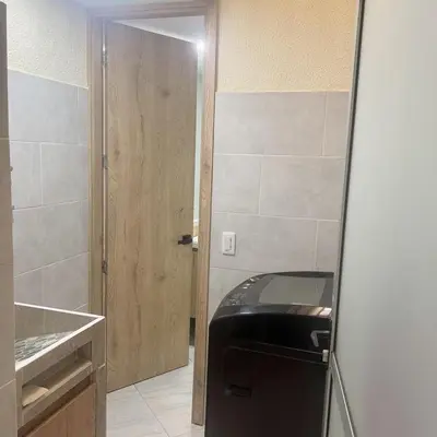 a door leading into a kitchen with a black refrigerator at Diamante 204 in Guatapé