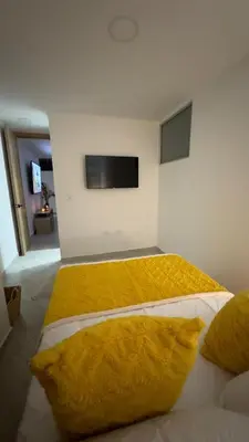 a bedroom with a bed with a yellow blanket on it at Diamante 204 in Guatapé