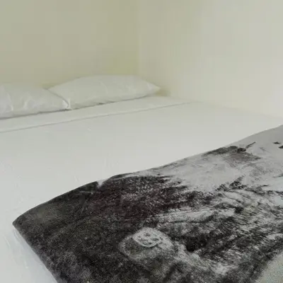 a bed with a black and white rug on it at Hotel Villa Nueva Comfort in Medellín
