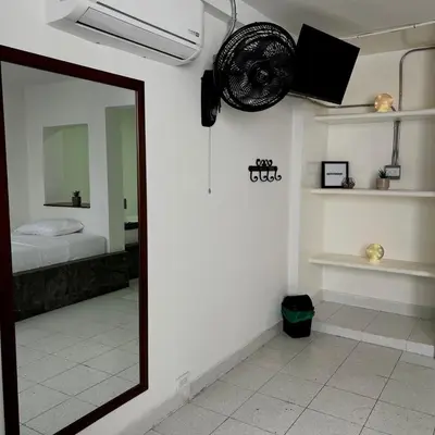 a mirror in a room with a bed and a fan at Hotel Villa Nueva Comfort in Medellín