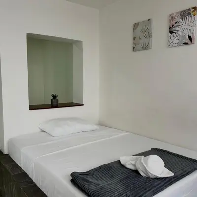 a white bed with a mirror and a towel on it at Hotel Villa Nueva Comfort in Medellín
