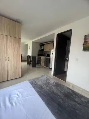 a large room with a bed and a kitchen at Lindo apartamento poblado 111 in Medellín