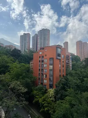 a red brick building in the middle of a city at Lindo apartamento poblado 111 in Medellín